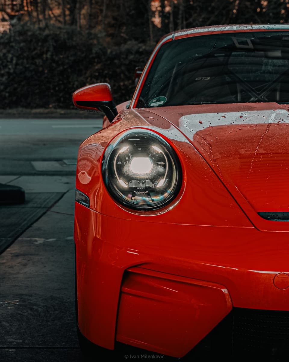 Nahaufnahme des Scheinwerfers eines Porsche 911 GT3 im Abendlicht.
